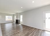 Thumbnail 2 of 21 - A large empty room with wooden floors and white walls. at Two Rivers Home Rentals, West Des Moines, IA 50266