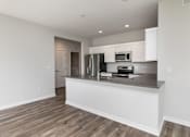 Thumbnail 3 of 21 - A kitchen with white cabinets and a wooden floor. at Two Rivers Home Rentals, Iowa 50266