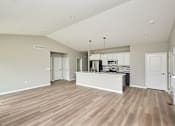 Thumbnail 8 of 21 - an empty kitchen and living room with a counter top at Two Rivers Home Rentals, Iowa 50266