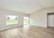 Thumbnail 9 of 21 - an empty living room with a large window and a door at Two Rivers Home Rentals, Iowa