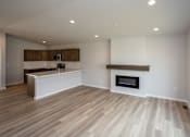 Thumbnail 18 of 21 - an empty living room with a fireplace and a kitchen at Two Rivers Home Rentals, West Des Moines