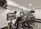 Thumbnail 17 of 28 - A row of treadmills and exercise bikes in a gym.