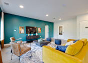 Thumbnail 12 of 28 - A living room with a yellow couch and a television.