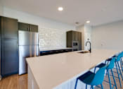 Thumbnail 15 of 28 - A kitchen with a white countertop and blue chairs.