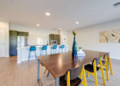Thumbnail 14 of 28 - A dining room with a wooden table and blue and yellow chairs.
