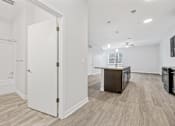 Thumbnail 39 of 52 - A white door is open to a kitchen area.