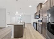 Thumbnail 40 of 52 - A modern kitchen with dark wood cabinets and stainless steel appliances.