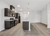 Thumbnail 43 of 52 - A kitchen with dark brown cabinets and a white island.