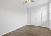 Thumbnail 16 of 52 - A room with a white wall and a wooden floor with a white closet.