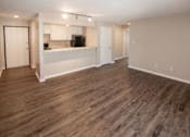 Thumbnail 2 of 90 - an empty living room and kitchen with a wood floor at Rosemont Place Apartments, Des Moines, IA, 50320