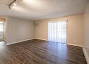 Thumbnail 3 of 90 - an empty living room with wood flooring and a window at Rosemont Place Apartments, Des Moines, 50320