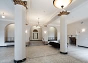 Thumbnail 7 of 13 - A large, empty room with white walls and a fireplace.