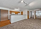Thumbnail 34 of 40 - an empty living room with a kitchen with a counter top at Autumn Park, South Dakota  