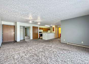 Thumbnail 17 of 40 - the living room and kitchen of an apartment with a carpeted floor at Autumn Park, Sioux Falls  