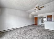 Thumbnail 27 of 40 - an empty living room with white walls and a ceiling fan at Autumn Park, Sioux Falls South Dakota  