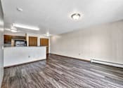 Thumbnail 19 of 40 - an empty living room with a white wall and wood flooring at Autumn Park, Sioux Falls, SD  