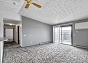 Thumbnail 26 of 40 - an empty living room with a ceiling fan and a sliding glass door at Autumn Park, Sioux Falls, 57106  