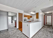 Thumbnail 28 of 40 - an empty kitchen with a counter top and a refrigerator at Autumn Park, Sioux Falls  