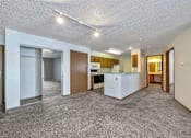 Thumbnail 16 of 40 - an empty living room and kitchen with a refrigerator and a sink at Autumn Park, Sioux Falls South Dakota  