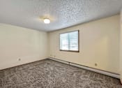 Thumbnail 18 of 40 - an empty living room with carpet and a window at Autumn Park, South Dakota  