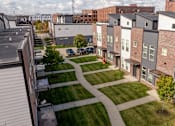 Thumbnail 36 of 37 - A view of a residential area with apartment buildings and a grassy area in the foreground.