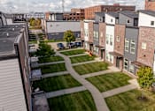 Thumbnail 24 of 37 - A view of a residential area with apartment buildings and a grassy area in the foreground.