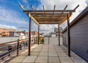 Thumbnail 21 of 37 - A wooden pergola on a rooftop patio.