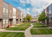Thumbnail 31 of 37 - A residential area with apartment buildings and a green lawn.