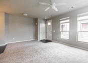 Thumbnail 5 of 37 - A spacious room with a ceiling fan and carpeted floor.