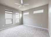 Thumbnail 9 of 37 - A spacious room with a ceiling fan and three windows.