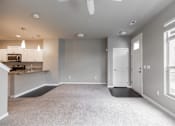 Thumbnail 7 of 37 - A spacious living room with a kitchen area in the background.