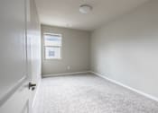 Thumbnail 12 of 37 - A room with a carpeted floor and a window.