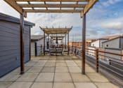 Thumbnail 20 of 37 - A patio with a pergola and a table set up for dining.