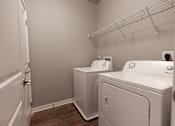 Thumbnail 13 of 37 - A laundry room with a washer and dryer.