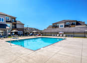 Thumbnail 30 of 50 - our apartments offer a swimming pool with a building in the background at Stonegate Crossing Apartments, Clive