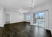 Thumbnail 26 of 50 - an empty living room with a sliding glass door to a balcony at Stonegate Crossing Apartments, Clive, IA
