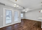 Thumbnail 23 of 50 - the living room and dining room of an apartment with wood flooring and white walls at Stonegate Crossing Apartments, IOWA, 50325