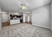 Thumbnail 22 of 50 - an empty living room and kitchen with a ceiling fan at Stonegate Crossing Apartments, Clive, 50325
