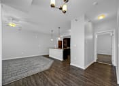 Thumbnail 21 of 50 - the living room and kitchen of a new home with white walls and wood flooring at Stonegate Crossing Apartments, Clive, IA, 50325