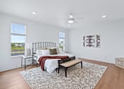 Thumbnail 9 of 77 - Spacious bedroom with platform bed and patterned area rug at The Flats at West Glen Apartments, Iowa, 50266