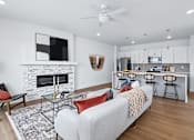 Thumbnail 4 of 77 - Open concept living area with fireplace and kitchen island at The Flats at West Glen Apartments, West Des Moines, 50266
