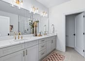Thumbnail 8 of 77 - Master bathroom with double sink vanity and gold fixtures at The Flats at West Glen Apartments, Iowa