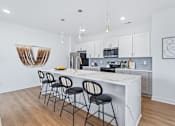 Thumbnail 74 of 77 - Kitchen island with marble countertop and four bar stools at The Flats at West Glen Apartments, West Des Moines, IA 50266