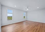 Thumbnail 70 of 77 - Empty bedroom with wood flooring and ceiling fan at The Flats at West Glen Apartments, Iowa
