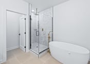 Thumbnail 69 of 77 - Freestanding soaking tub with gold floor mount faucet at The Flats at West Glen Apartments, Iowa, 50266