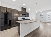 Thumbnail 19 of 52 - A kitchen with a white counter and black appliances.