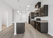 Thumbnail 13 of 52 - A modern kitchen with dark wood cabinets and a white countertop.