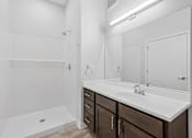 Thumbnail 26 of 52 - A white bathroom with a sink, mirror, and shower.