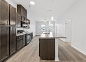 Thumbnail 22 of 52 - A modern kitchen with dark wood cabinets and a central island.