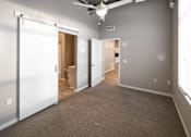 Thumbnail 14 of 40 - an empty living room with a closet and a door to a bathroom at Velocity Apartments, Iowa